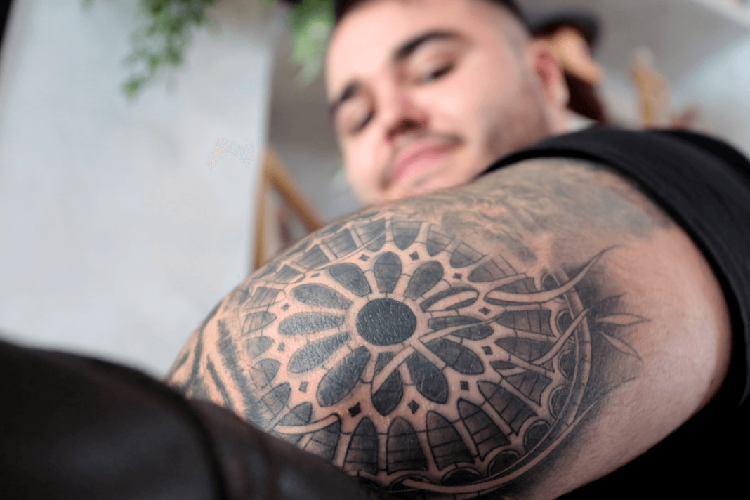 El DJ Eric García muestra el tatuaje del rosetón de la Catedral de León en su brazo
