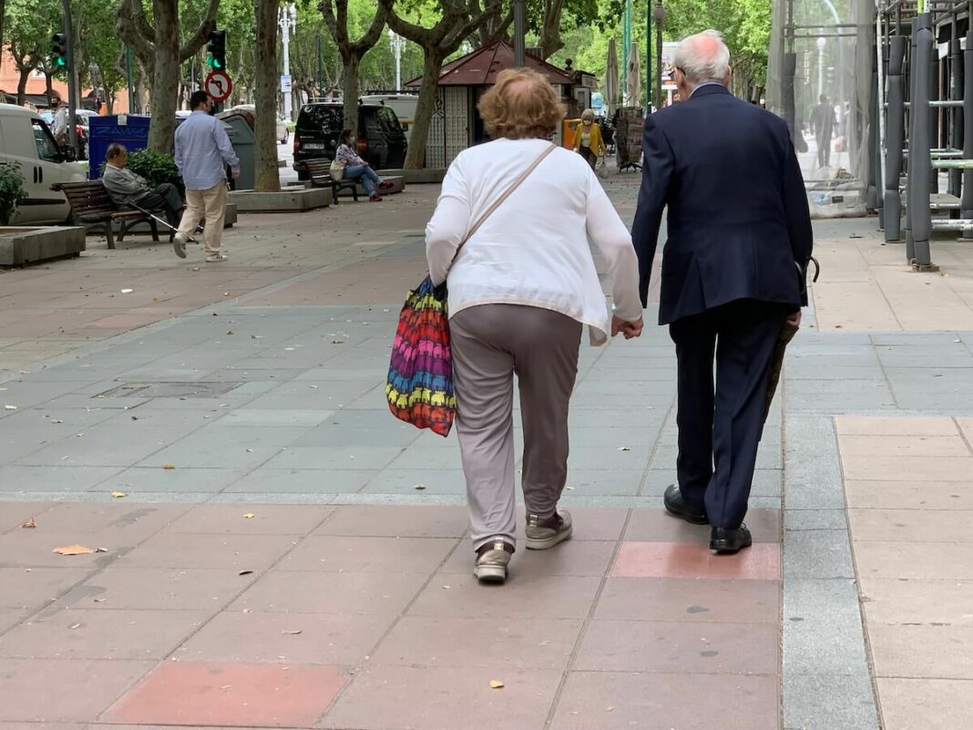 pareja Una pareja de octogenarios pasea de la mano por una calle central de Valladolid
